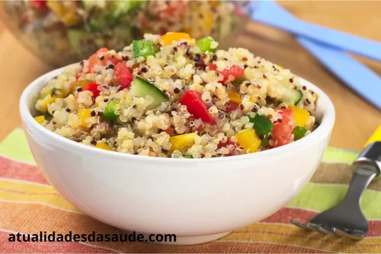 Salada com quinoa e vegetais frescos em uma tigela, com ingredientes coloridos como alface, tomate, cenoura e fatias de pepino.
